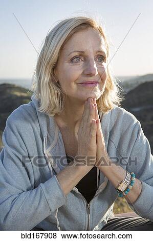 Stock Photo - Close up of Caucasian woman with hands clasped. Fotosearch