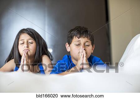 Close up of concerned Hispanic children praying View Large Photo Image Stock Image - Close up of concerned Hispanic children praying. Fotosearch