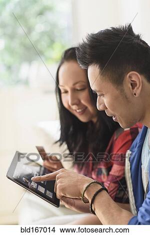 Close up of couple shopping online on digital tablet View Large Photo Image Picture - Close up of couple shopping online on digital tablet. Fotosearch
