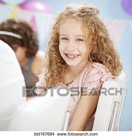 Picture - Close up of girl smiling at birthday party. Fotosearch