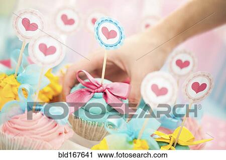 Close up of hand choosing cupcake at birthday party View Large Photo Image Stock Image - Close up of hand choosing cupcake at birthday party. Fotosearch