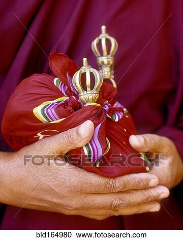Stock Image - Close up of hands holding ceremonial bells . Fotosearch