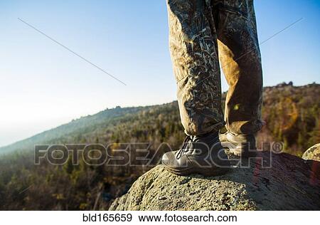 Close up of hiker standing on remote rock View Large Photo Image Stock Photo - Close up of hiker standing on remote rock. Fotosearch