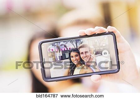 Close up of Hispanic couple taking selfie outdoors View Large Photo Image Stock Photo - Close up of Hispanic couple taking selfie outdoors. Fotosearch