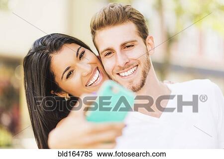 Close up of Hispanic couple taking selfie outdoors View Large Photo Image Stock Photography - Close up of Hispanic couple taking selfie outdoors. Fotosearch