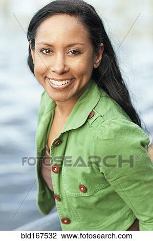Stock Image - Close up of Indian woman smiling outdoors. Fotosearch