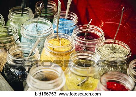 Stock Image - Close up of jars of pigment powder. Fotosearch