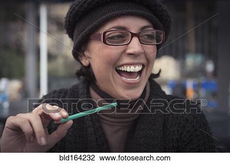 Stock Image - Close up of laughing Caucasian woman holding pencil. Fotosearch