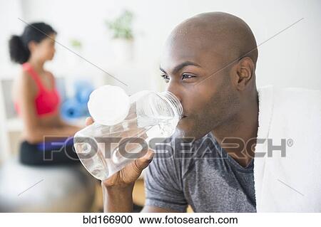 Stock Image - Close up of man drinking water bottle. Fotosearch