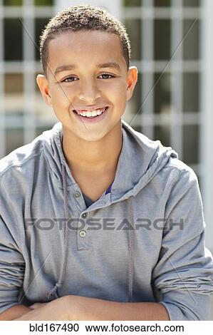 Stock Image - Close up of mixed race boy smiling outdoors. Fotosearch