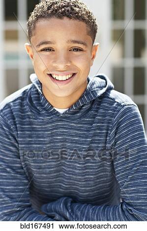 Stock Image - Close up of mixed race boy smiling outdoors. Fotosearch