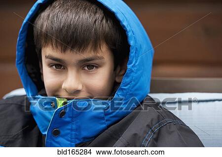Picture - Close up of mixed race boy wearing parka and hood. Fotosearch