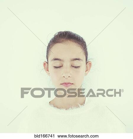 Stock Image - Close up of mixed race girl with eyes closed. Fotosearch