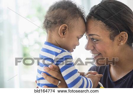 Close up of mixed race mother holding baby son View Large Photo Image Picture - Close up of mixed race mother holding baby son. Fotosearch