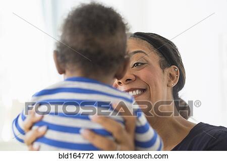 Close up of mixed race mother holding baby son View Large Photo Image Stock Image - Close up of mixed race mother holding baby son. Fotosearch
