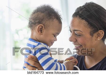 Close up of mixed race mother holding baby son View Large Photo Image Stock Image - Close up of mixed race mother holding baby son. Fotosearch