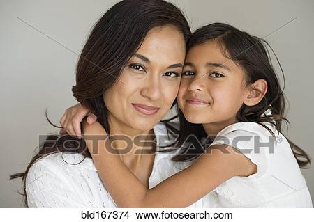 Picture - Close up of mother and daughter hugging. Fotosearch