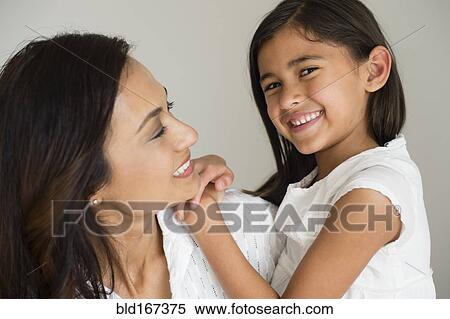 Stock Photography - Close up of mother and daughter hugging. Fotosearch
