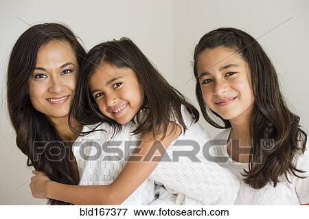 Stock Photo - Close up of mother and daughters hugging. Fotosearch