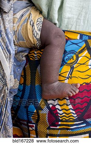 Stock Photo - Close up of mother carrying baby with traditional wrap. Fotosearch