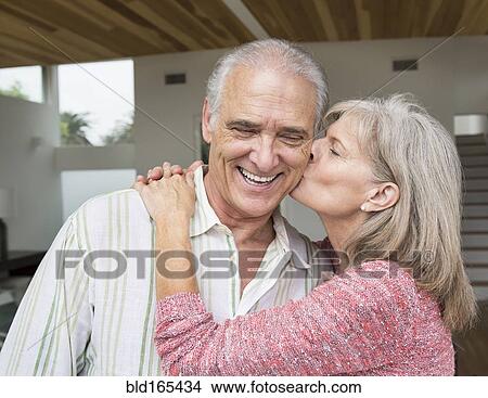 Picture - Close up of older Caucasian woman kissing husband. Fotosearch
