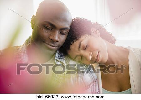 Stock Image - Close up of relaxing couple hugging. Fotosearch