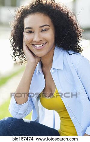 Close up of smiling Black woman sitting outdoors View Large Photo Image Picture - Close up of smiling Black woman sitting outdoors. Fotosearch