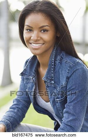 Close up of smiling Black woman sitting outdoors View Large Photo Image Stock Photography - Close up of smiling Black woman sitting outdoors. Fotosearch