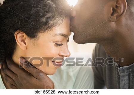 Stock Photo - Close up of smiling couple kissing. Fotosearch