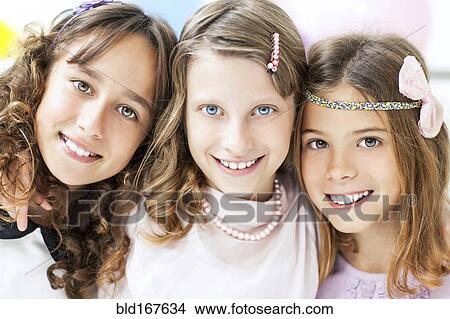 Close up of smiling girls hugging View Large Photo Image Picture - Close up of smiling girls hugging. Fotosearch