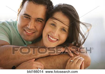 Close up of smiling Hispanic couple hugging View Large Photo Image Picture - Close up of smiling Hispanic couple hugging. Fotosearch