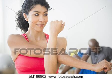 Close up of woman stretching in gym View Large Photo Image Stock Image - Close up of woman stretching in gym. Fotosearch