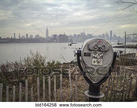 Stock Photo - Coin-operated binoculars viewing city skyline on urban waterfront. Fotosearch