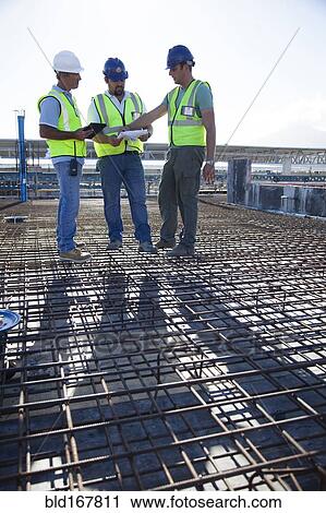 Construction workers talking on rebar at construction site View Large Photo Image Stock Image - Construction workers talking on rebar at construction site. Fotosearch