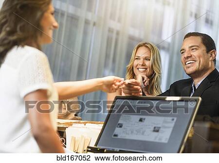 Couple checking in to hotel with concierge View Large Photo Image Stock Image - Couple checking in to hotel with concierge. Fotosearch
