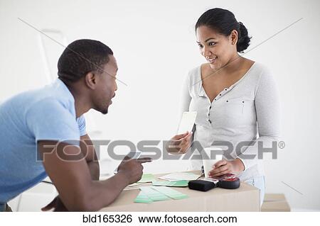 Stock Photograph - Couple choosing paint swatches in new home. Fotosearch