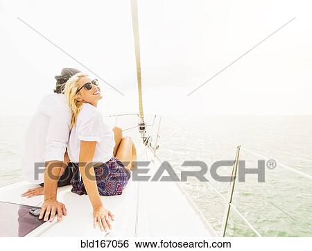 Couple cuddling on deck of sailboat View Large Photo Image Stock Photograph - Couple cuddling on deck of sailboat. Fotosearch