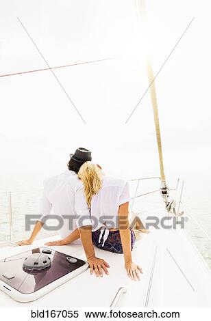 Couple cuddling on deck of sailboat View Large Photo Image Stock Photography - Couple cuddling on deck of sailboat. Fotosearch