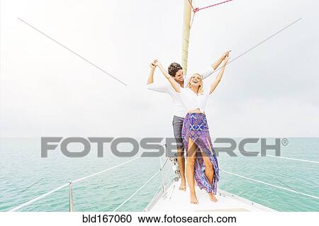 Stock Image - Couple dancing on deck of sailboat. Fotosearch