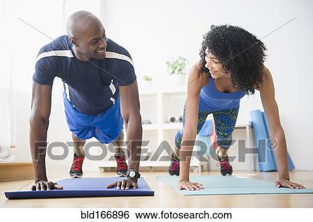 Stock Photograph - Couple doing push-ups in gym. Fotosearch