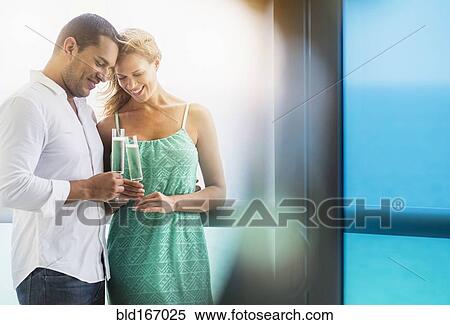 Stock Photography - Couple drinking champagne at window. Fotosearch