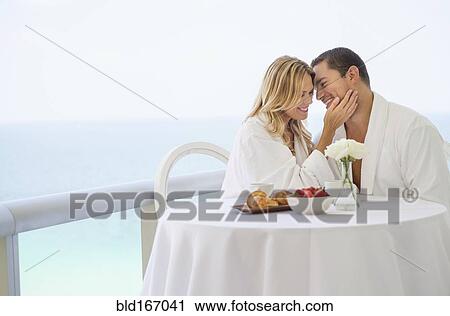 Couple eating breakfast on balcony View Large Photo Image Stock Image - Couple eating breakfast on balcony. Fotosearch