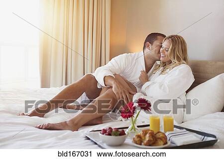 Couple enjoying breakfast in bed in hotel room View Large Photo Image Stock Image - Couple enjoying breakfast in bed in hotel room. Fotosearch
