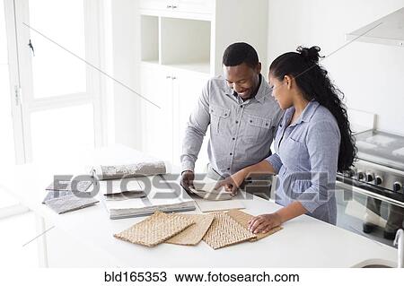 Couple examining fabric swatches in new home View Large Photo Image Stock Image - Couple examining fabric swatches in new home. Fotosearch