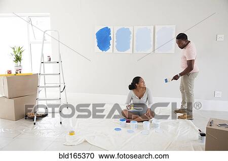 Couple examining paint samples in new home View Large Photo Image Stock Image - Couple examining paint samples in new home. Fotosearch