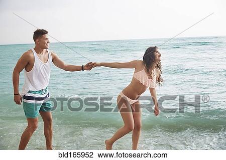 Couple holding hands on beach View Large Photo Image Stock Image - Couple holding hands on beach. Fotosearch
