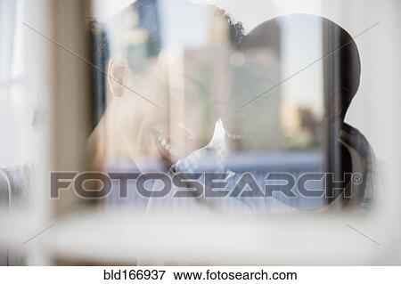 Stock Photo - Couple hugging behind window. Fotosearch