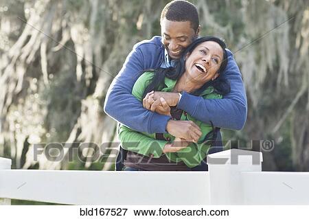 Stock Photo - Couple hugging near fence. Fotosearch