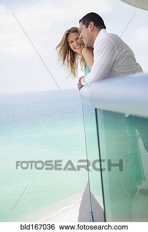 Couple hugging on balcony over ocean View Large Photo Image Stock Photograph - Couple hugging on balcony over ocean. Fotosearch