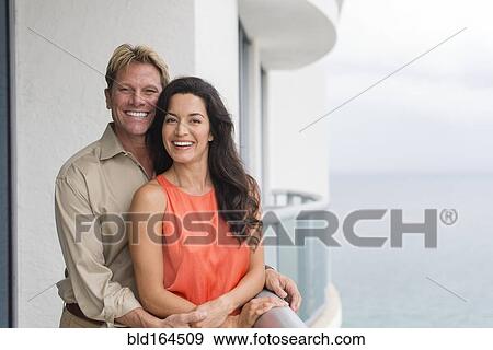 Stock Photo - Couple hugging on balcony. Fotosearch